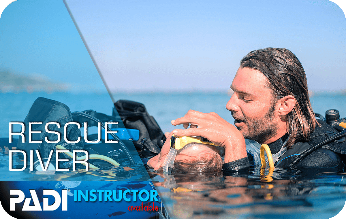 Diver practicing rescue skills during a PADI scuba diving course, performing an underwater rescue of a fellow diver, demonstrating safety techniques and emergency preparedness in clear blue waters